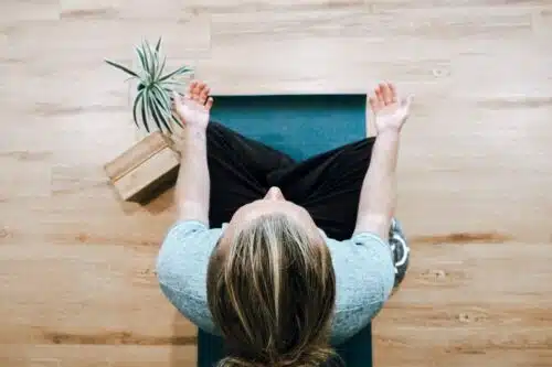 woman in black shirt and gray pants sitting on brown wooden bench